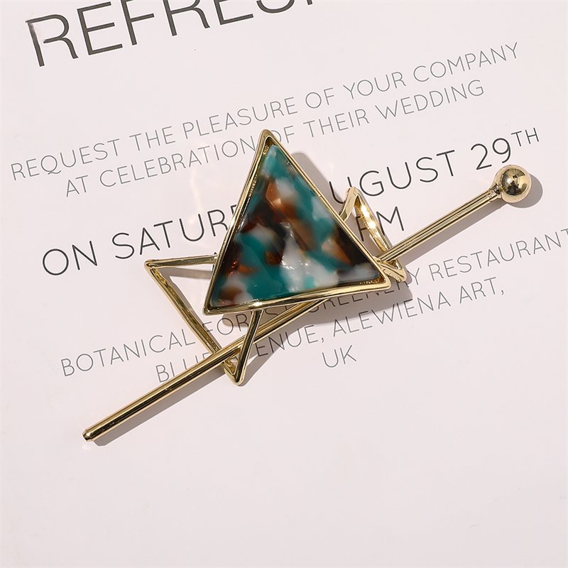 Cora Skydespænde | Jade af Chris Rubin har en geometrisk marmoreret trekant i blågrønt, brunt og hvidt i en guldramme, der giver et stilfuldt touch til enhver bryllupsinvitation eller tilbehør.