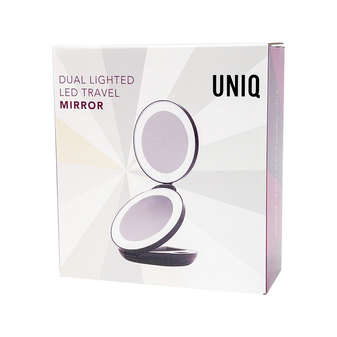 En produktæske med UNIQ Kompakt Dobbelt Rejsespejl med LED og x10 Forstørrelse | Sort, der viser det åbne runde spejl, fed tekst for LED og x10-forstørrelse på en lys, mønstret baggrund.