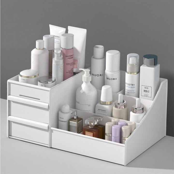 UNIQ Kosmetik Organizer | P110 | Hvid fra UNIQ opbevarer pænt hudpleje og kosmetik med skuffer i venstre side og rum i højre side, der vises mod en grå baggrund.