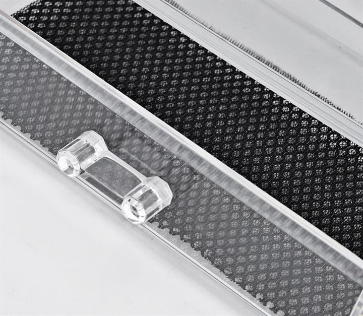 Nærbillede af UNIQ Makeup Akryl Organizer med 1 Skuffe + Top (SF-1061) med klart hængslet låg og tekstureret sort skridsikker bund fra UNIQ, perfekt til smykkeopbevaring, vist på en hvid overflade.