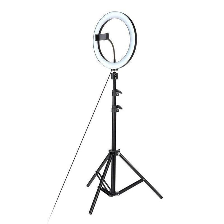 UNIQ Pro Ringlight Studio fra UNIQ giver professionelt lys, er monteret på et justerbart stativ og har en praktisk telefonholder i midten - perfekt til billeder og videoer, vist mod en hvid baggrund.