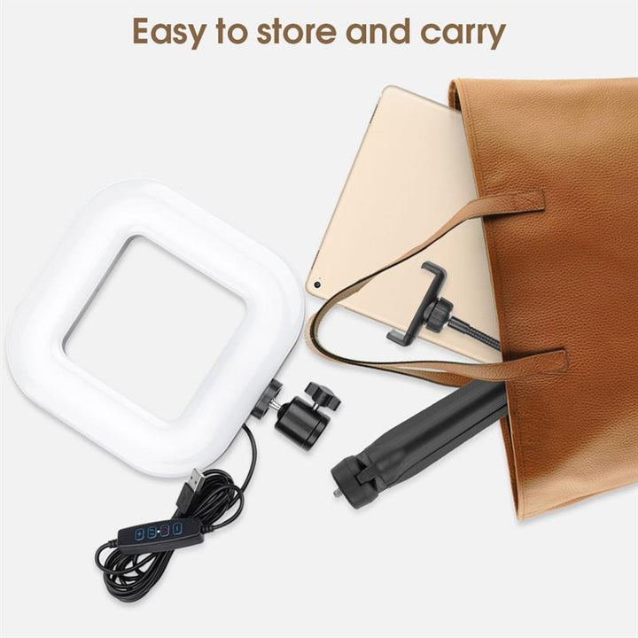 I en brun taske ligger UNIQ Selfie Ringlight til iPhone og Android med stativ og tilbehør. På en hvid baggrund står der: Let at opbevare og bære. Mærke: UNIQ.