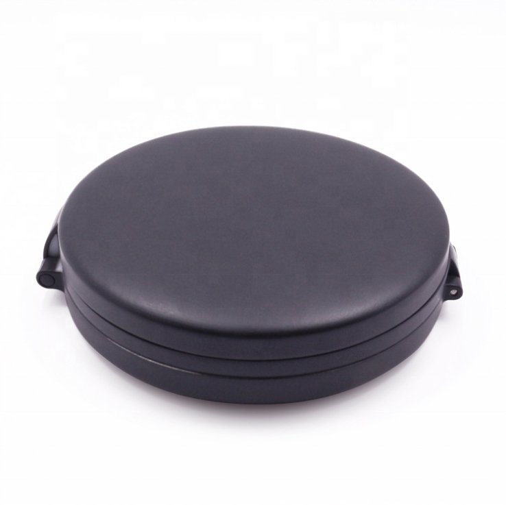 UNIQ Tri-fold Kompakt Rejsespejl med LED i sort fra UNIQ vises lukket mod en hvid baggrund; det har en glat flade, rund form og små lukkebeslag på hver side.