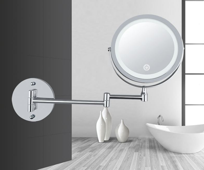 UNIQ Vægmonteret LED Kosmetikspejl med justerbar, rund form, leddelt arm og forstørrelse fra UNIQ hænger i det moderne badeværelse med hvidt badekar, dekorative vaser og trægulv. Perfekt som makeupspejl.