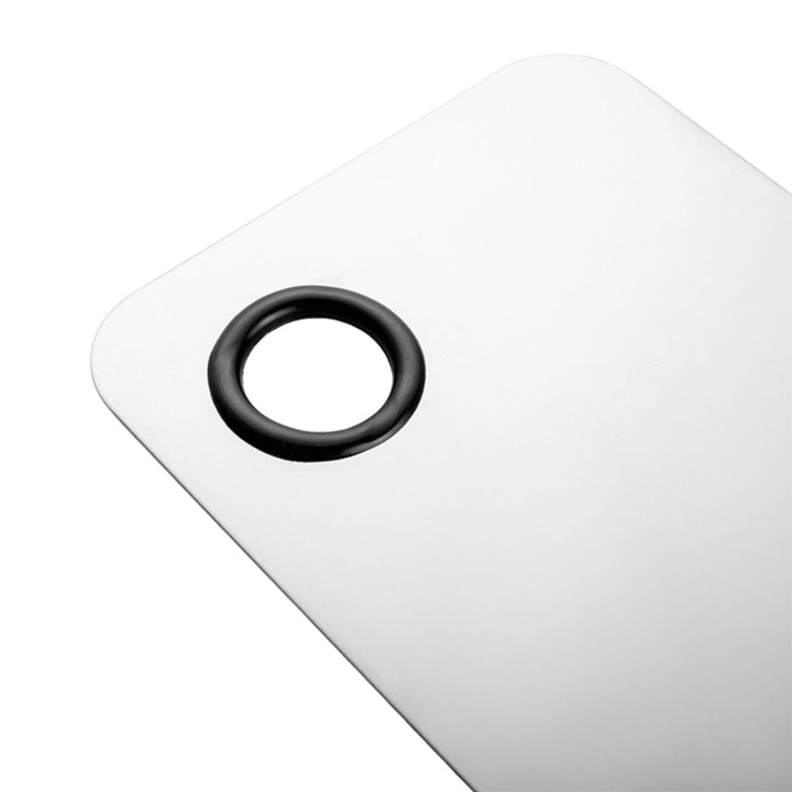 Nærbillede af Technique PRO Professional Makeup Mixing Palette – en hvid, rektangulær palet med et afrundet hjørne og et hul med sort kant, så den kan hænges op. Den glatte overflade er perfekt til præcis udjævning af foundation, hvilket gør den til et uundværligt redskab for makeup-artister eller et elegant supplement til dit skønhedssæt.