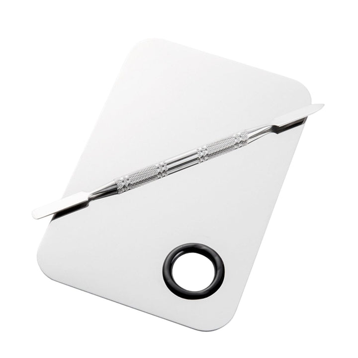 Technique PRO Professional Makeup Mixing Palette, der er fremstillet af rustfrit stål med afrundede kanter og et praktisk cirkulært tommelfingerhul i det ene hjørne, leveres sammen med en blandespatel af metal, der ligger diagonalt hen over den rektangulære overflade – perfekt til nem udjævning af foundation.