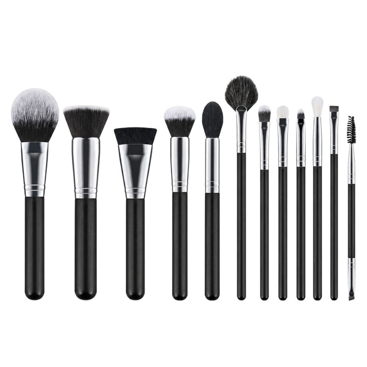 Technique PRO Galactic Ray Makeupbørste Sæt indeholder tolv makeupbørster med sorte skafter i forskellige former og størrelser, herunder øjenbørster og ansigtsbørster, som alle er pænt anbragt på en hvid baggrund – et uundværligt makeupbørstesæt fra Technique PRO til enhver skønhedsrutine.