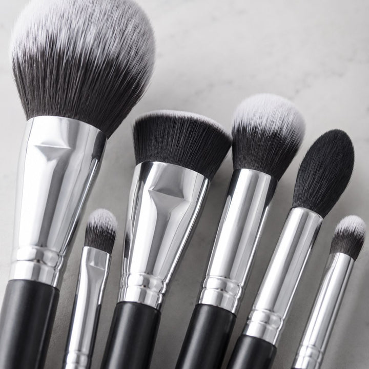 Vi præsenterer Technique PRO Galactic Ray Makeupbørste-sættet – et sofistikeret sæt fra Technique PRO bestående af 12 makeupbørster med elegante sorte skafter og sølvfarvede hylster, smukt anbragt på en lys, marmoreret overflade. Sættet indeholder både øjenbørster og ansigtsbørster i forskellige størrelser og former, der er perfekte til at skabe et fejlfrit look.