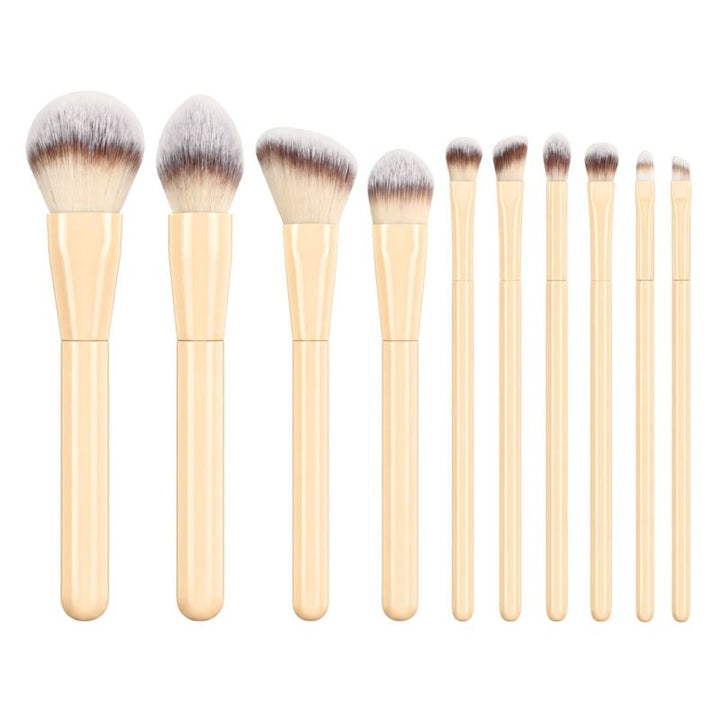 Technique PRO Buttercream Makeupbørste Sæt indeholder 10 makeupbørster med gule skafter og hvide børstehår, der er anbragt i en række fra den største til den mindste, og omfatter en række forskellige ansigtsbørster og børsteformer til forskellige makeup-formål.
