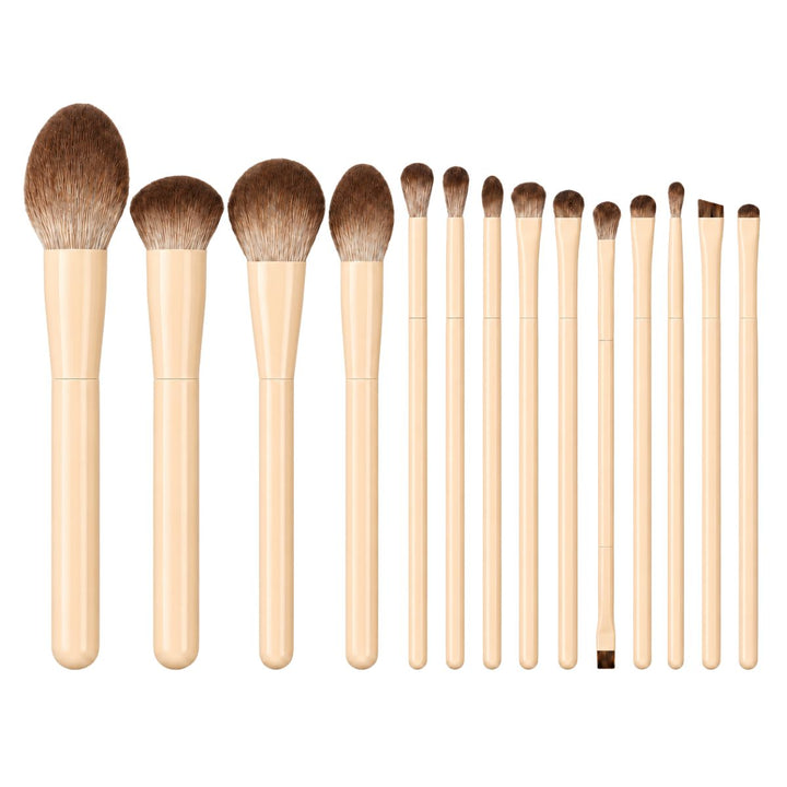 Fjorten makeupbørster med beige håndtag fra Technique PRO Vanilla Makeupbørste-sættet er placeret lodret i en række på en hvid baggrund. Dette elegante sæt fra Technique PRO byder på alsidige redskaber til en fejlfri påføring og forener funktionalitet med minimalistisk stil.
