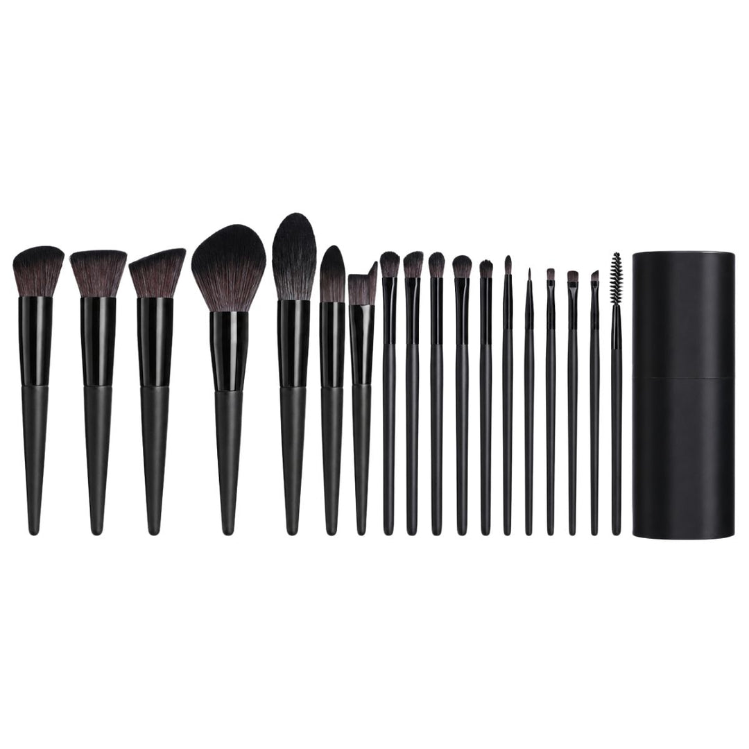 Et sortiment bestående af 18 Technique PRO Raven-makeupbørster med sorte skafter, opstillet på række ved siden af et matchende sort, cylindrisk etui. Dette professionelle børstesæt fra Technique PRO er ideelt til at skabe fejlfri makeup-looks hver gang.