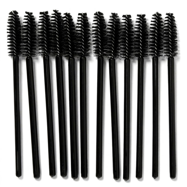 Ti sorte mascara-børster fra Technique PRO, »Øjenvippebørster – sort, 10 stk.«, er anbragt på række på en hvid baggrund og fremviser de perfekte børster til påføring af mascara eller pleje af øjenvippeforlængelser.
