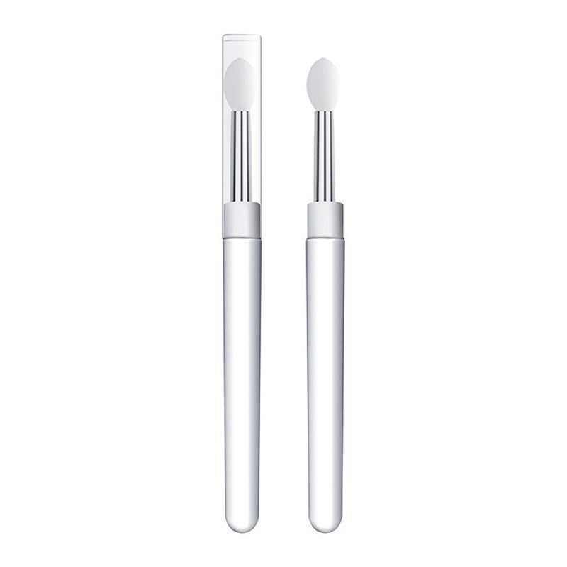 Selvfølgelig! Her er en omskrevet version af sætningen, hvor jeg har brugt dine produktoplysninger: To Universel Makeup Dubbe-børster i silikone fra Technique PRO, begge med hvide håndtag, sølvfarvede skafter og spidser af silikone – den ene med en hætte af gennemsigtig plast og den anden uden – står oprejst på en hvid baggrund. Disse alsidige applikatorer er designet til præcis påføring på læber, negle, øjenskygge m.m. og kombinerer stil og funktionalitet for at forbedre din skønhedsrutine.