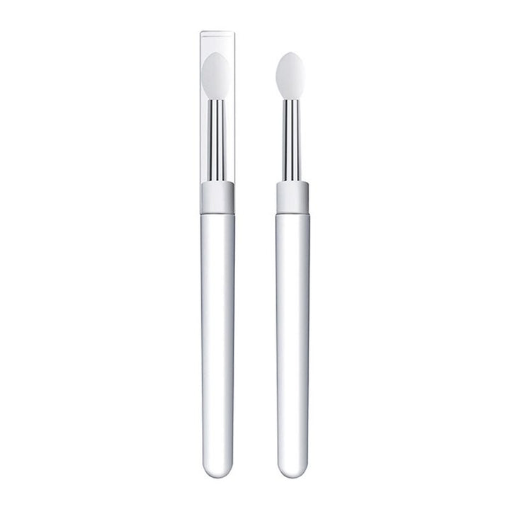 Selvfølgelig! Her er en omskrevet version af sætningen, hvor jeg har brugt dine produktoplysninger: To Universel Makeup Dubbe-børster i silikone fra Technique PRO, begge med hvide håndtag, sølvfarvede skafter og spidser af silikone – den ene med en hætte af gennemsigtig plast og den anden uden – står oprejst på en hvid baggrund. Disse alsidige applikatorer er designet til præcis påføring på læber, negle, øjenskygge m.m. og kombinerer stil og funktionalitet for at forbedre din skønhedsrutine.