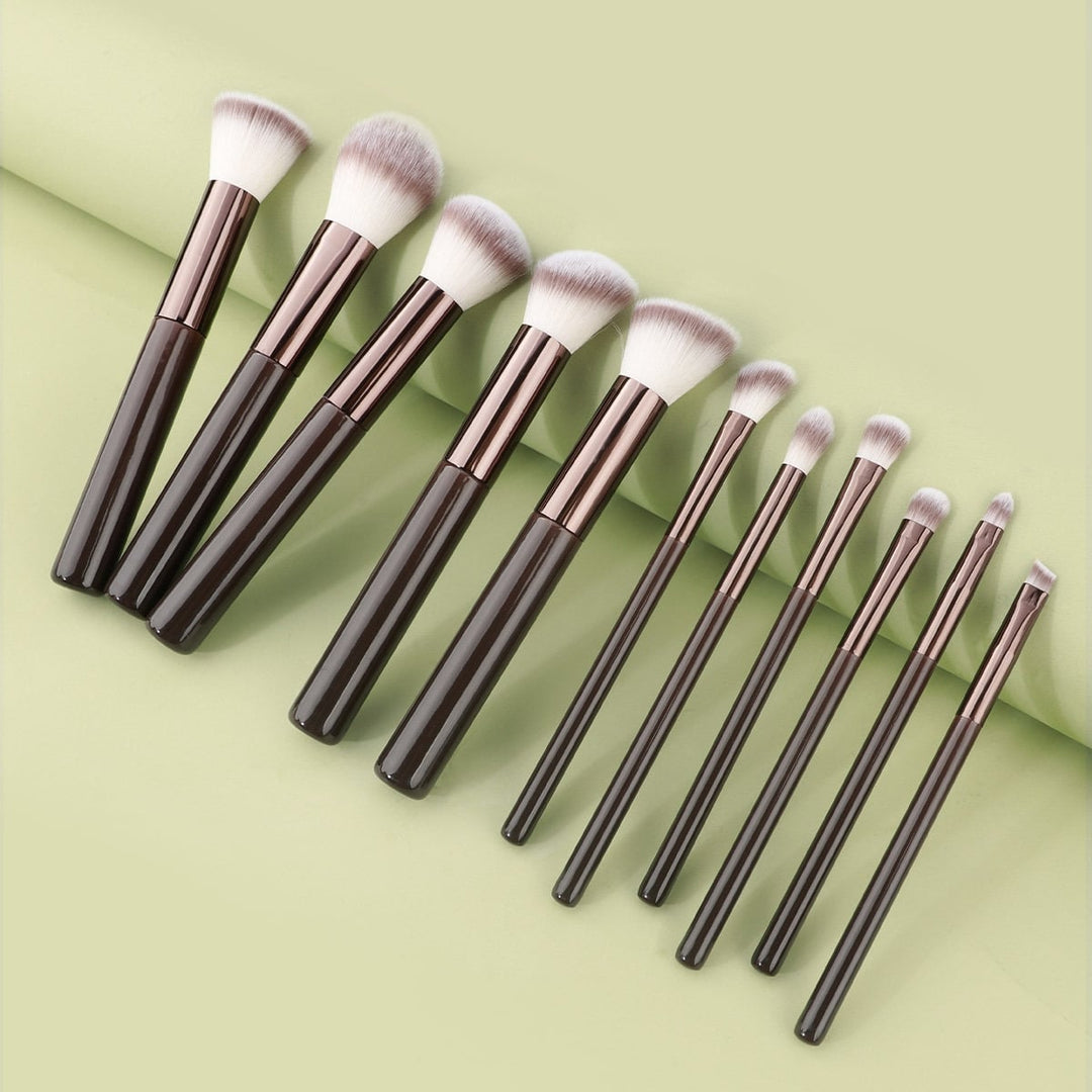 Technique PRO Chocolate Bronze Makeupbørste Sæt med elleve børster med mørkebrune skafter og tofarvede syntetiske børstehår, der er anbragt på række.