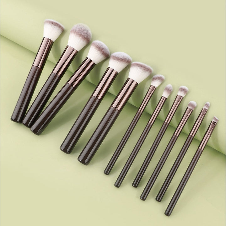Technique PRO Chocolate Bronze Makeupbørste Sæt med elleve børster med mørkebrune skafter og tofarvede syntetiske børstehår, der er anbragt på række.