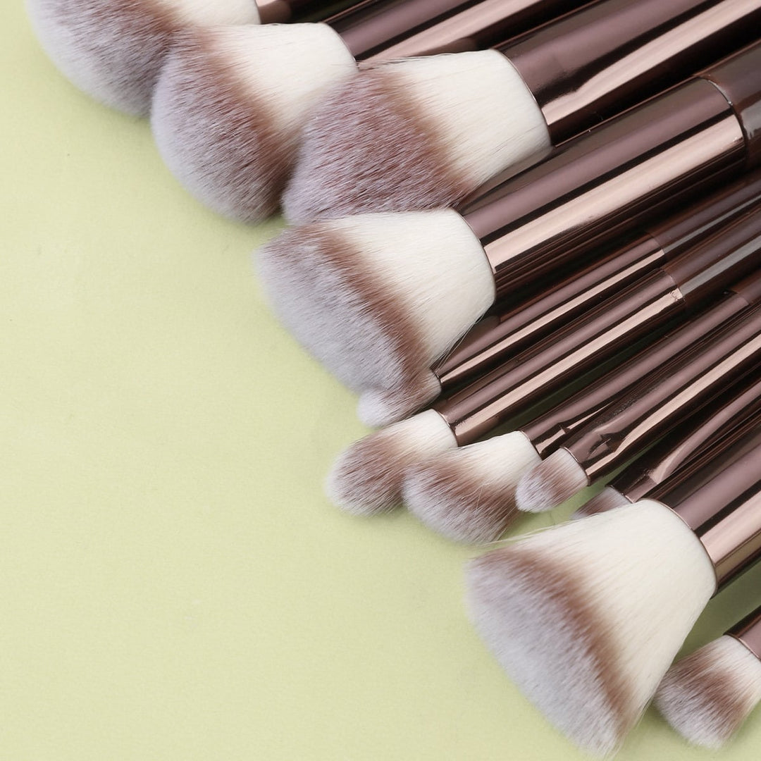 Et Technique PRO Chocolate Bronze Makeupbørste-sæt bestående af elleve makeupbørster med metalliske skafter og tofarvede syntetiske børstehår, der er anbragt i vifteform.