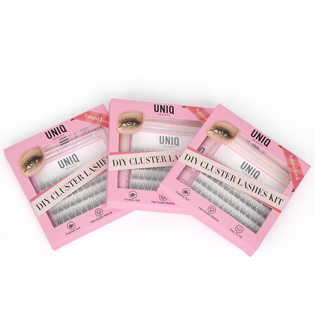 Tre pink UNIQ Lash Extension Starter Kits fra Stylemekka.dk er arrangeret overlappende og viser hver især klyngevipper og Bond & Seal-applikatorer gennem klare emballagevinduer.