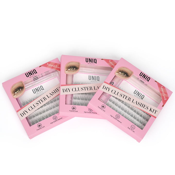 Tre pink UNIQ Lash Extension Starter Kits fra Stylemekka.dk er arrangeret overlappende og viser hver især klyngevipper og Bond & Seal-applikatorer gennem klare emballagevinduer.