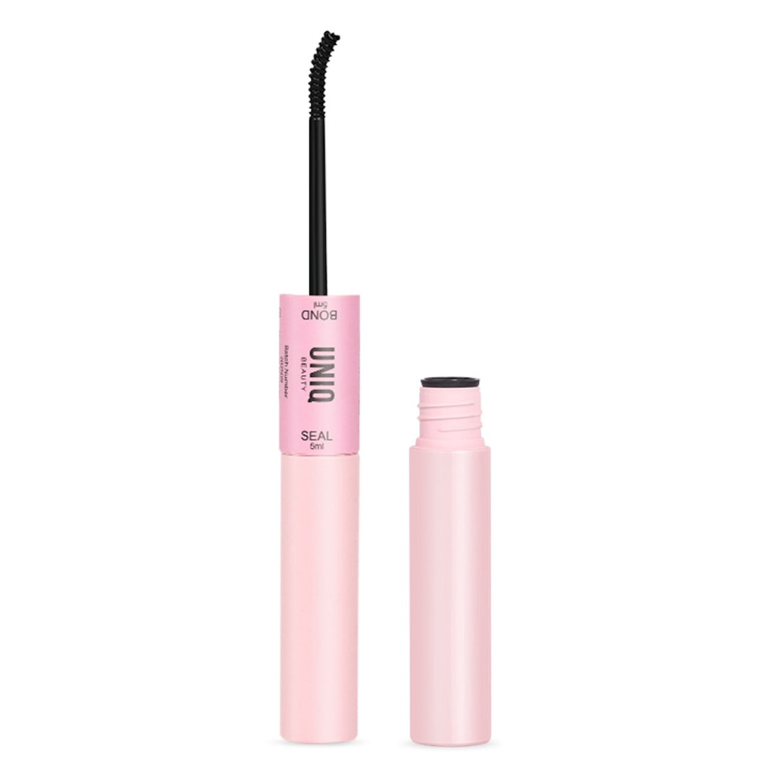 UNIQ Lash Extension Starter Kit fra Stylemekka.dk har en pink tube med teksten UNIQ og SEAL og en buet sort mascarastav - ideel til at blande med klyngevipper. Den opretstående hætte og den åbne tube er vist på en hvid baggrund.